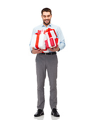 Image showing happy young man holding gift boxes