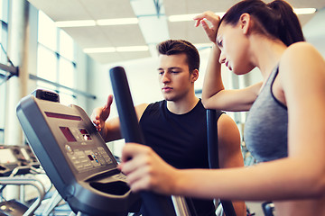 Image showing woman with trainer exercising on stepper in gym