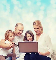 Image showing happy family with laptop computer and credit card