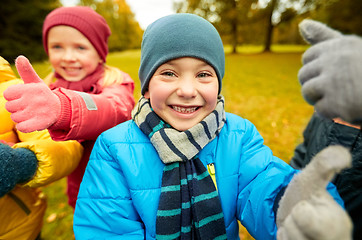 Image showing happy children showing thumbs up in autumn park