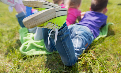 Image showing close up of kids lying on picnic blanket outdoors