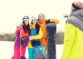 Image showing happy friends with snowboards and smartphone