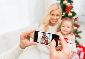 Image showing man taking picture of his family by smatrphone