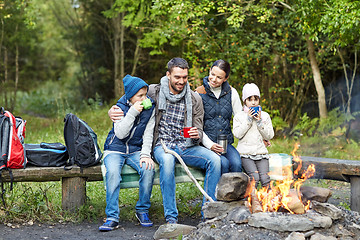 Image showing happy family sitting on bench at camp fire