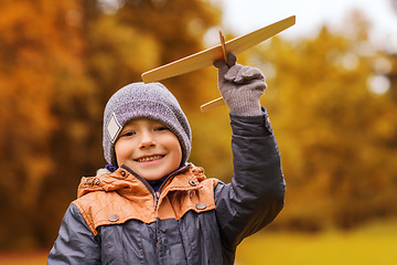 Image showing happy little boy playing with toy plane outdoors