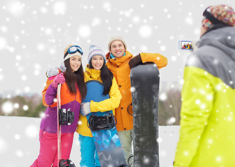 Image showing happy friends with snowboards and smartphone