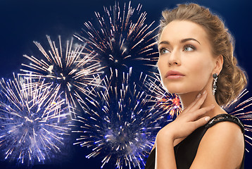 Image showing beautiful woman wearing earrings over firework