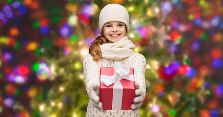 Image showing girl in hat, muffler and gloves with gift box