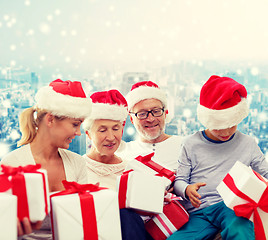 Image showing happy family in santa helper hats with gift boxes