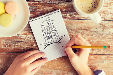 Image showing close up of hands drawing in notebook