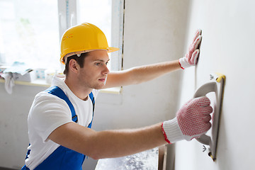 Image showing smiling builder with grinding tool indoors