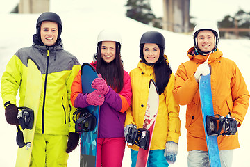 Image showing happy friends in helmets with snowboards