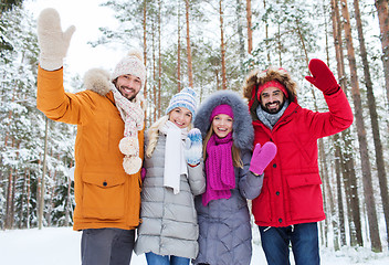 Image showing group of friends waving hands in winter forest