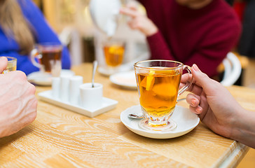 Image showing close up of female hand with tea  cup at cafe