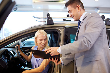 Image showing happy woman with car dealer in auto show or salon