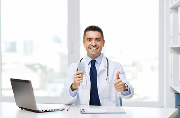 Image showing smiling doctor with tablets showing thumbs up