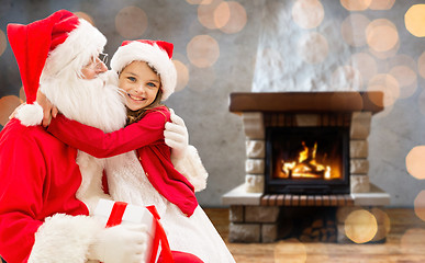 Image showing smiling family with santa claus and gift at home