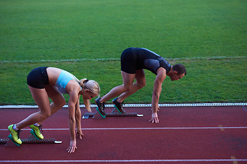 Image showing woman group  running on athletics race track from start