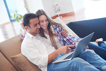 Image showing relaxed young couple working on laptop computer at home