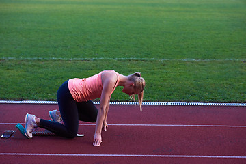 Image showing pixelated design of woman  sprinter leaving starting blocks