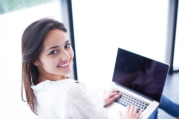 Image showing relaxed young woman at home working on laptop computer