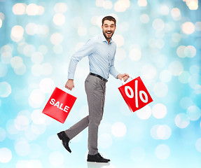Image showing smiling man walking with red shopping bag