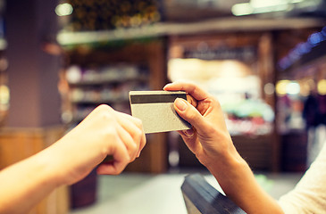 Image showing close up of hands giving credit card in mall