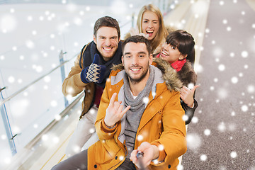 Image showing happy friends taking selfie on skating rink