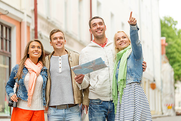 Image showing group of smiling friends with map and photocamera