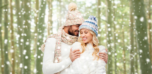 Image showing happy couple in winter clothes hugging over forest