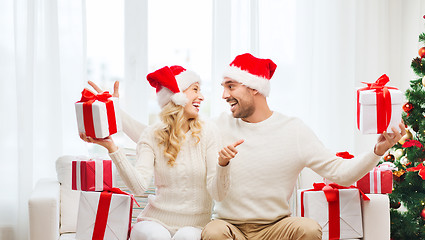 Image showing happy couple with christmas gifts and thumbs up