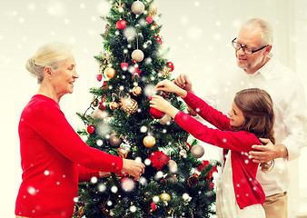 Image showing smiling family decorating christmas tree at home