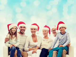 Image showing happy family in santa helper hats sitting on couch