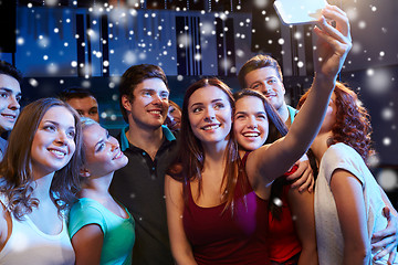 Image showing friends with smartphone taking selfie in club