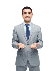Image showing happy businessman in suit showing empty palms