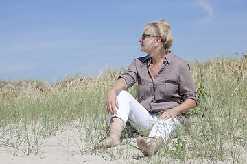 Image showing Vacationer sitting in the dunes