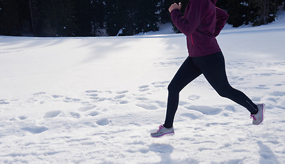 Image showing yougn woman jogging outdoor on snow in forest