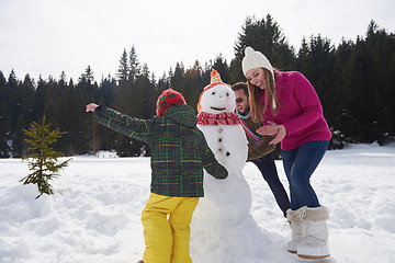 Image showing happy family building snowman