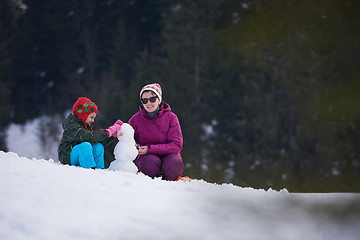 Image showing happy family building snowman