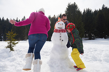 Image showing happy family building snowman