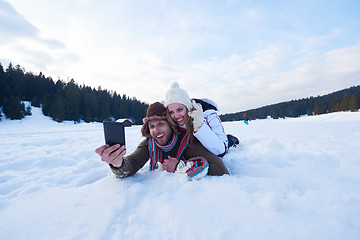 Image showing romantic couple have fun in fresh snow and taking selfie