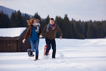 Image showing couple having fun and walking in snow shoes