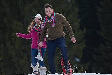 Image showing couple having fun and walking in snow shoes