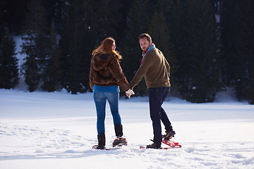 Image showing couple having fun and walking in snow shoes