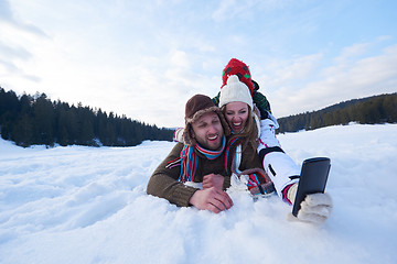 Image showing romantic couple have fun in fresh snow and taking selfie