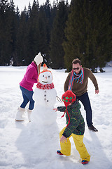 Image showing happy family building snowman