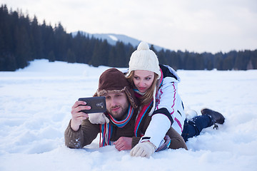 Image showing romantic couple have fun in fresh snow and taking selfie