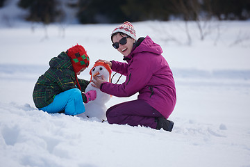 Image showing happy family building snowman