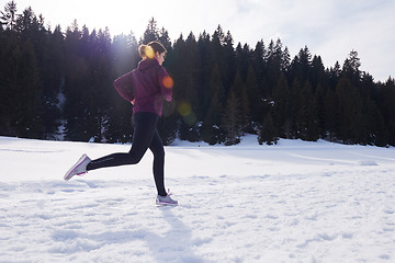 Image showing yougn woman jogging outdoor on snow in forest