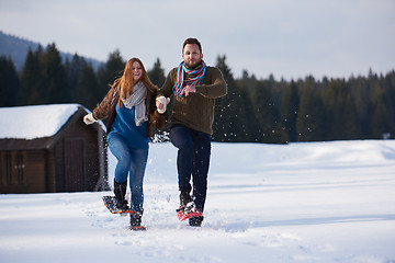 Image showing couple having fun and walking in snow shoes